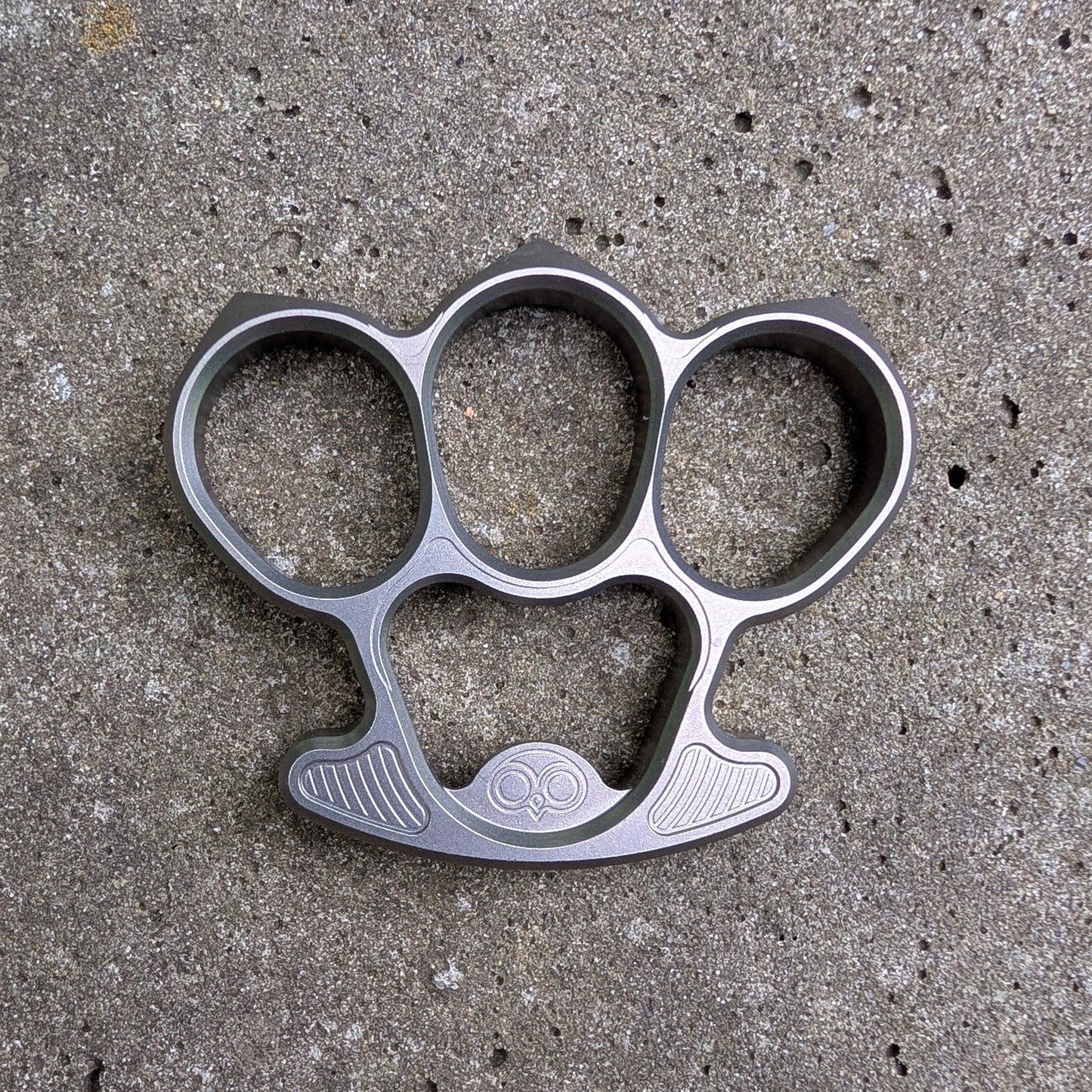 Titanium bottle opener on a concrete surface